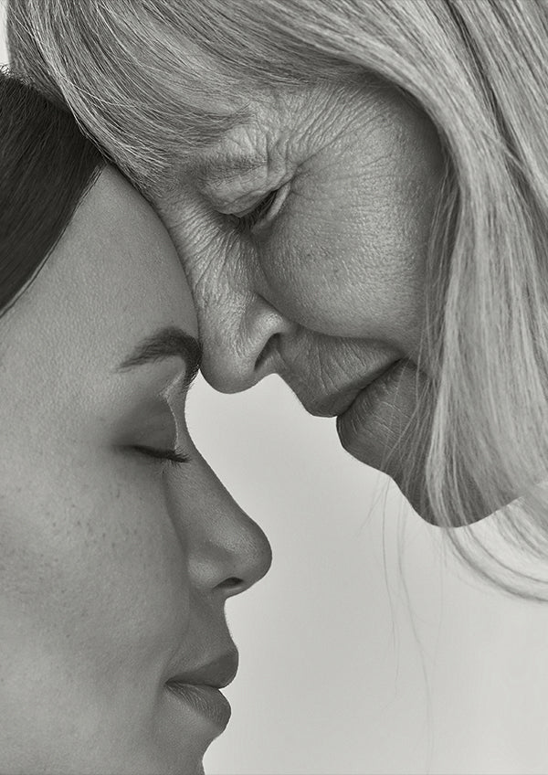 Black and white close-up of two women's faces in profile, intimate and contemplative moment