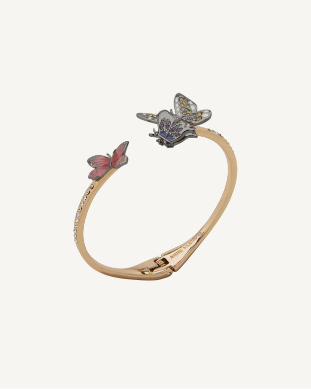 Product Coming Soon. Anne Klein open-cuff bangle bracelet in gold tone featuring two butterfly charms in blue and pink enamel