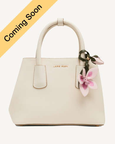 Anne Klein mini structured satchel in cream leather with a pink floral charm and gold-tone hardware