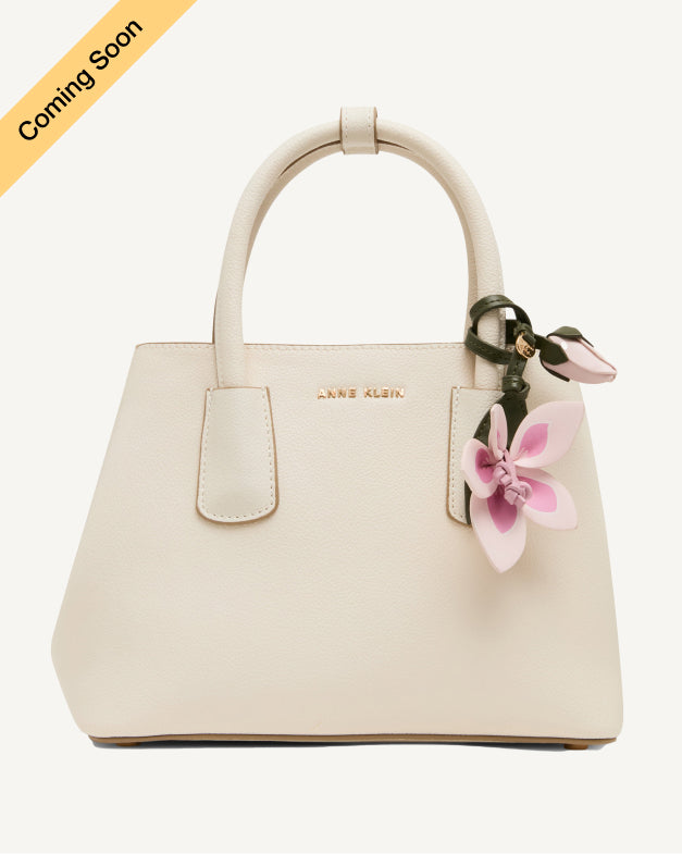 Anne Klein mini structured satchel in cream leather with a pink floral charm and gold-tone hardware