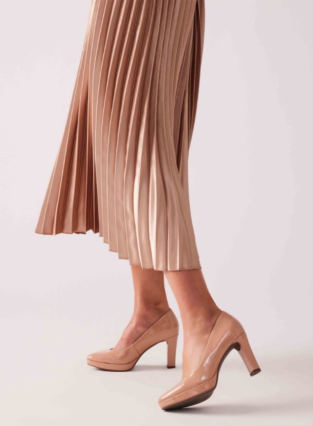 patent nude shoes and pleated skirt on model
