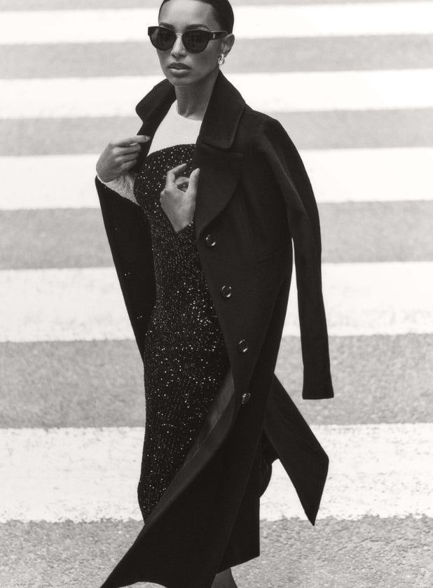female model walking in the street wearing anne klein dress and jacket 