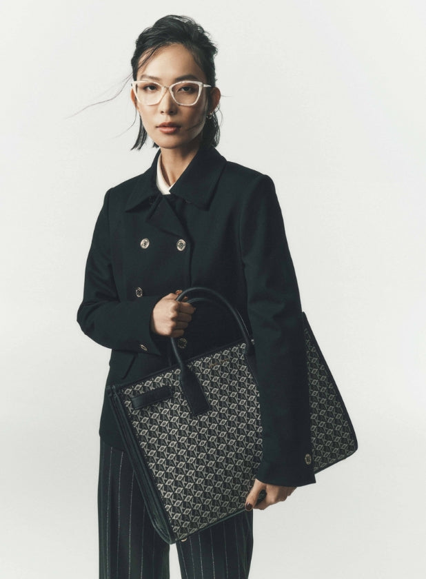 female model wearing anne klein jacket holding an anne klein bag 