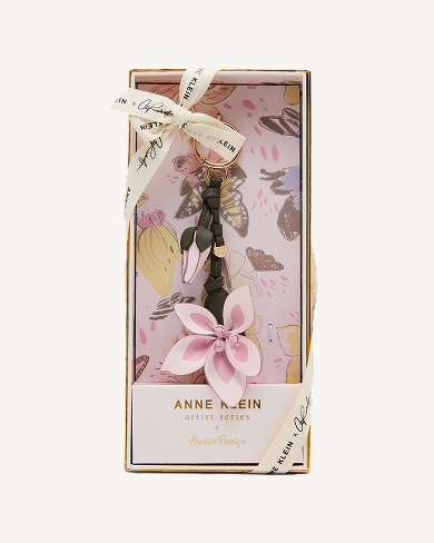 Anne Klein Artist Series gift set in illustrated pink floral box featuring a tassel handbag charm with a pink flower, tied with a branded ribbon