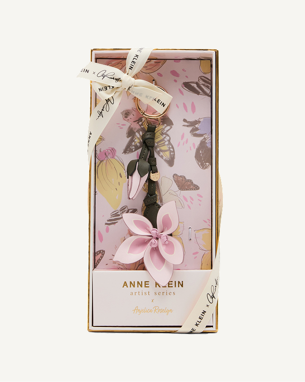 Anne Klein Artist Series gift set in illustrated pink floral box featuring a tassel handbag charm with a pink flower, tied with a branded ribbon