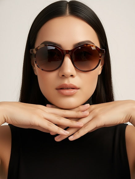 Woman in sunglasses posing with hands under her chin