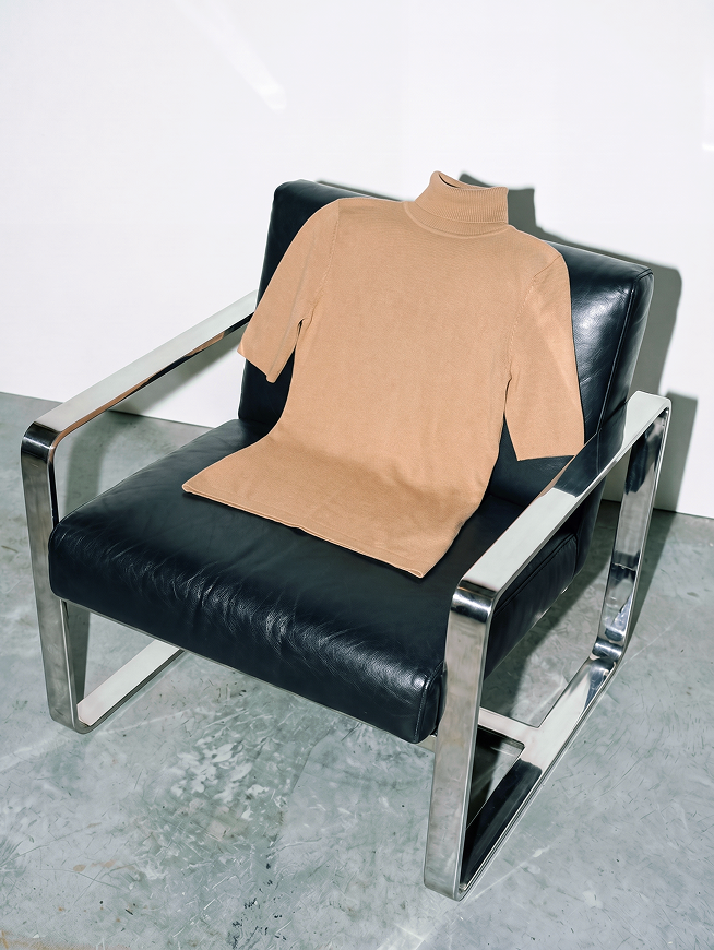 Beige turtleneck sweater with short sleeves on black leather chair, link to three-quarter-sleeve turtleneck sweater