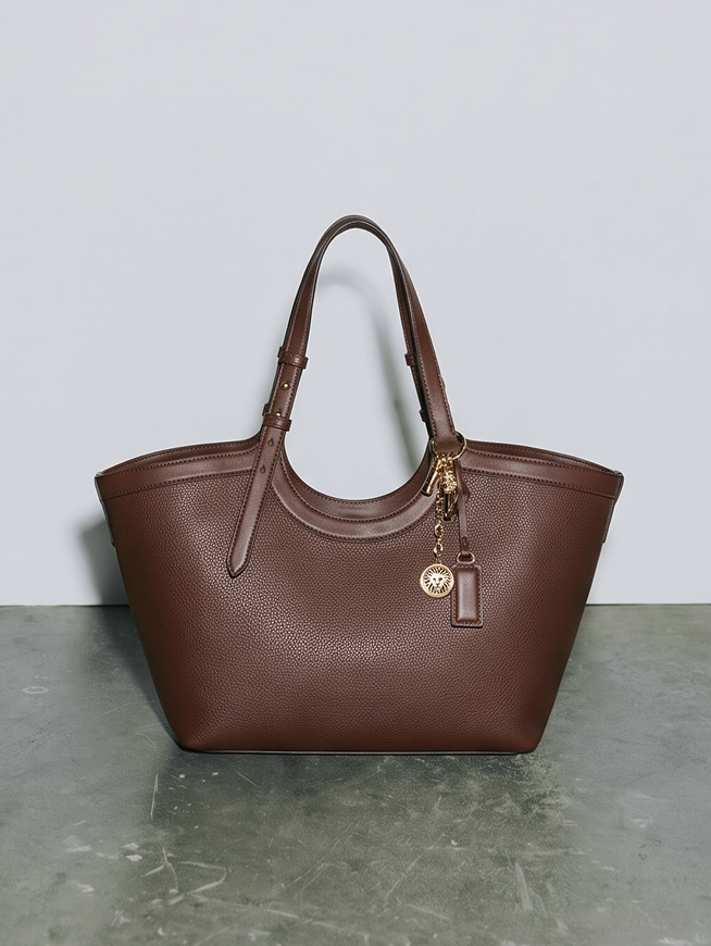 Brown pebbled leather tote bag with dual handles and charm keychain, link to East-West Tote product page