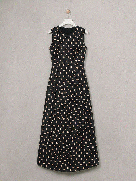 Black sleeveless A-line dress with all-over cream polka dot pattern on hanger
